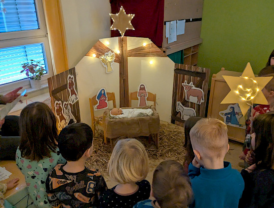 Staunend vor der Krippe stehen